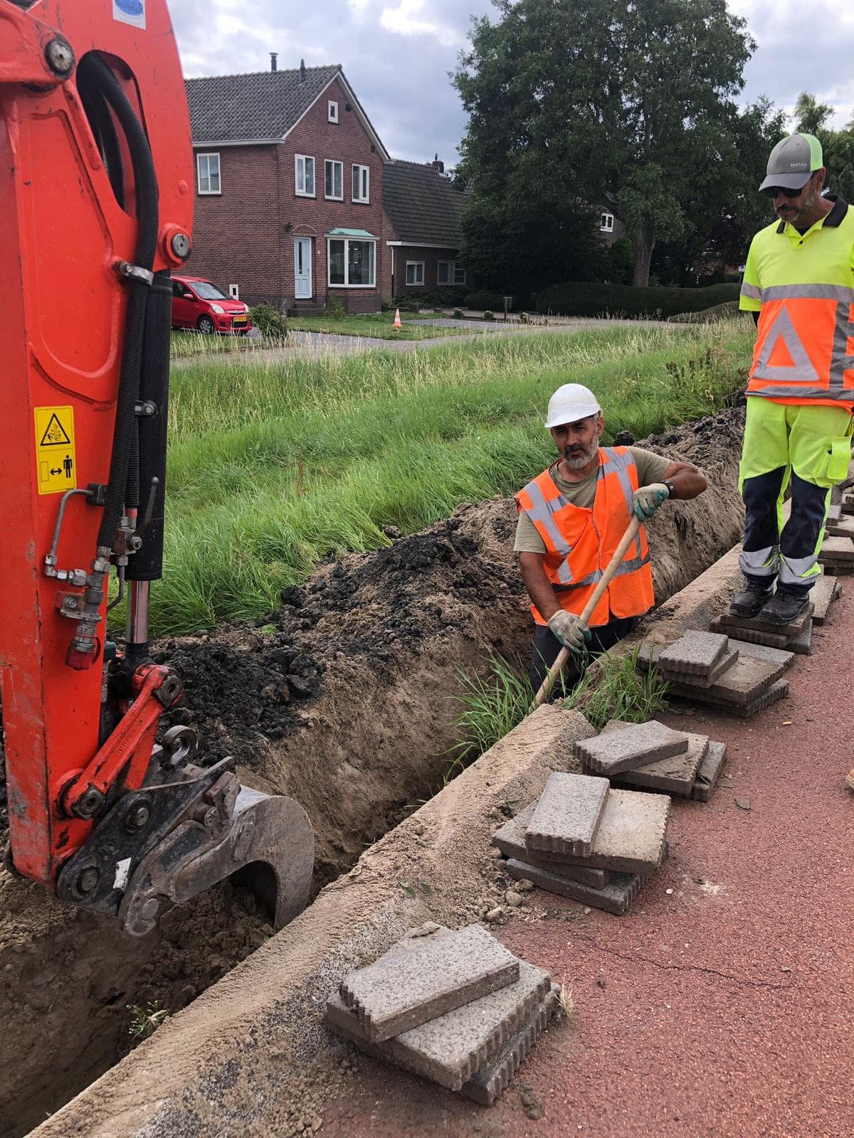 Monteur van Pro Demirel Fiber bij graafwerk naast een minigraver
