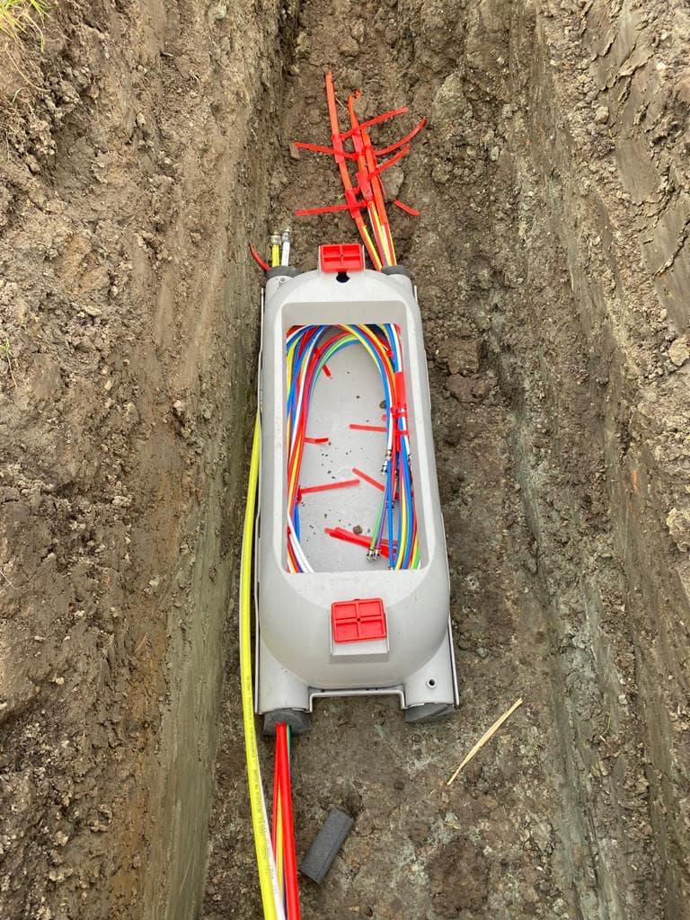 Glasvezel verdeelkast met gekleurde fiberkabels in een sleuf