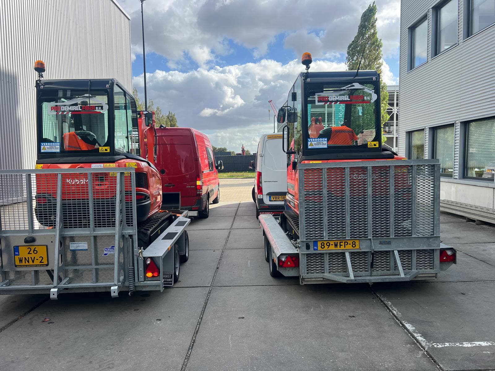 Bedrijfswagens en Kubota minigravers van Pro Demirel Fiber bij de werkplaats in Den Haag